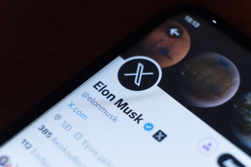 Elon Musk's Twitter profile with the new X logo displayed on a smartphone screen.